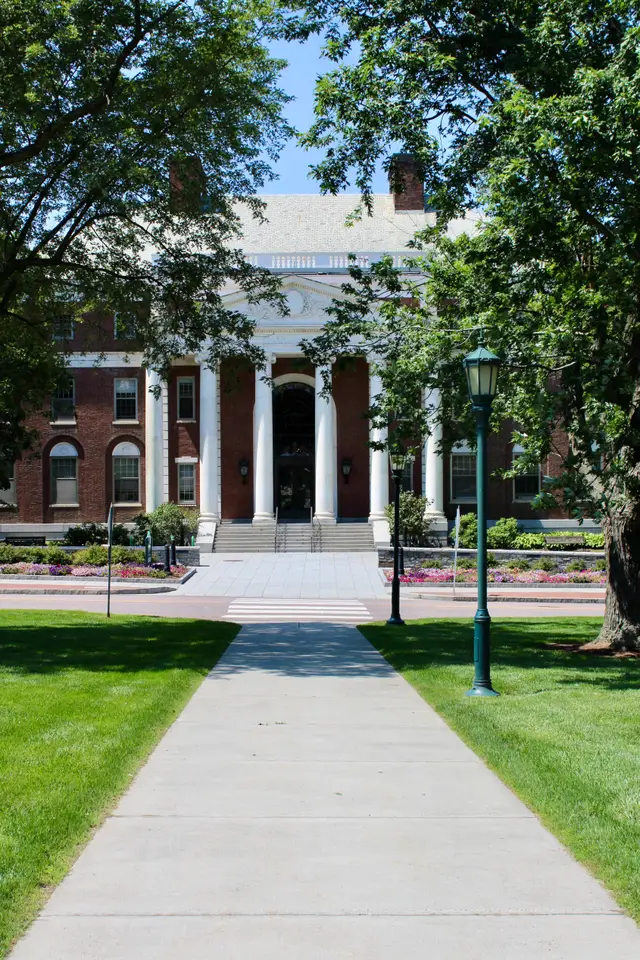 Path leading to a red-brick academic building with a white neoclassical portico.